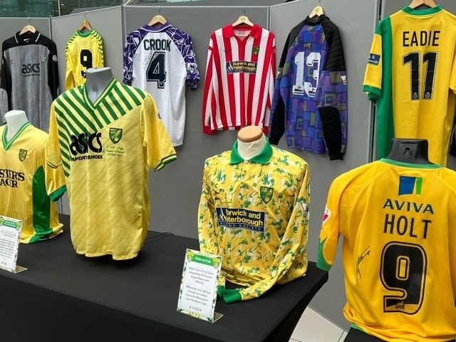 Two visitors giving thumbs up at the Norwich Shirts stand at the March 2024 Football Collectors Fair