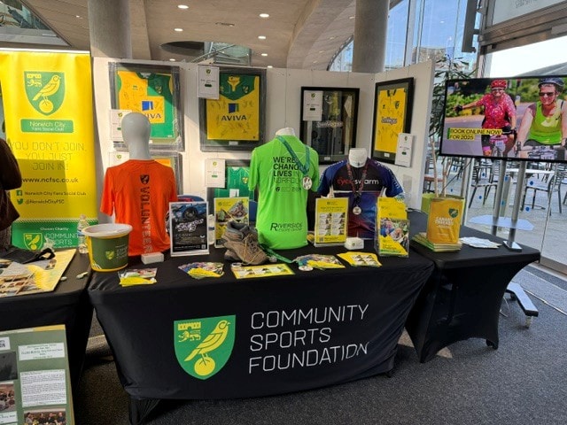 Community Sports Foundation indoor display with Norwich City merchandise at the March 2025 Football Collectors Fair