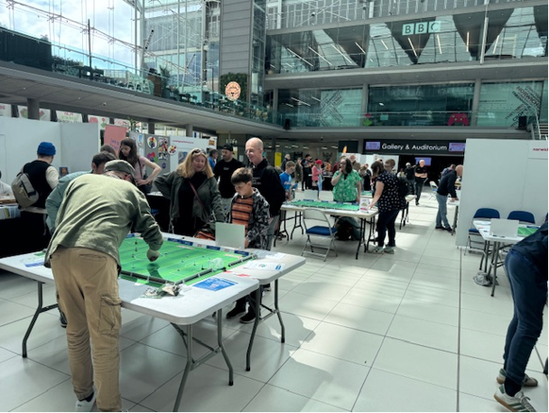 Busy Subbuteo tables with families and visitors at the May 2025 Subbuteo Event, The Forum Norwich